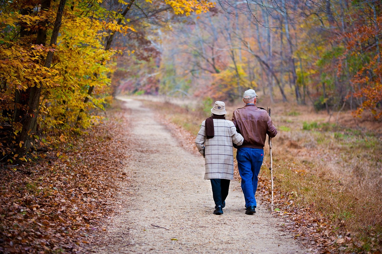 Happy senior couple walking together at an Orange County assisted living community, showing the active lifestyle and companionship available through quality senior care placement services
